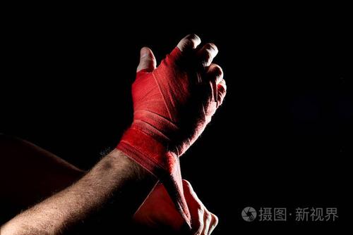 一个拳击手红色绷带在他的手上孤立的黑暗模糊背景, 特写