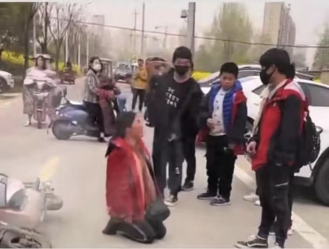 妈妈当街向儿子下跪磕头求儿子回去上学儿子对此却无动于衷