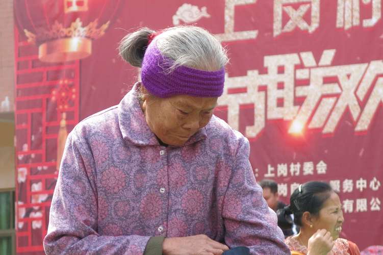 年迈的老奶奶在看手表,希望表演不要那么快结束,因为表演太精彩了