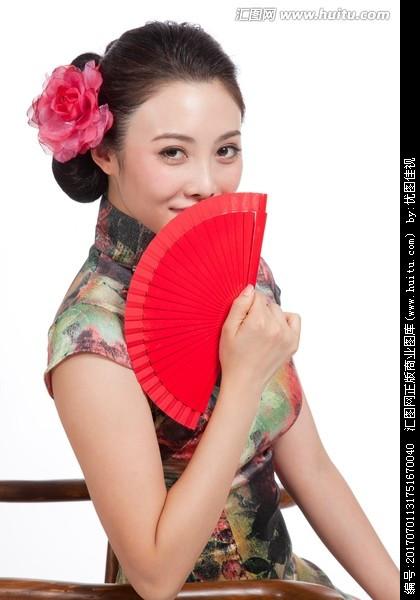 棚拍身穿中国传统服装的年轻女人和扇子