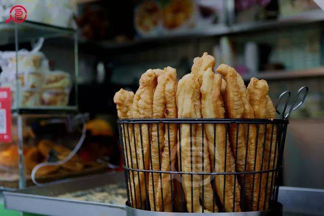 或许是出货量大的原因,油条炸好后被整齐地罗列在铁丝编制的圆形筐里