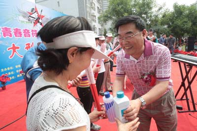 常营社区工委书记吉广平为登楼选手颁发环保奖品.