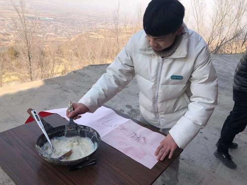 王宇松同学在在对联上涂浆糊,这样会使对联贴得更牢固