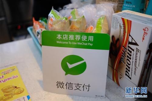 这是泰国曼谷街头一家便利店内摆放的印有"本店推荐使用微信支付"字样