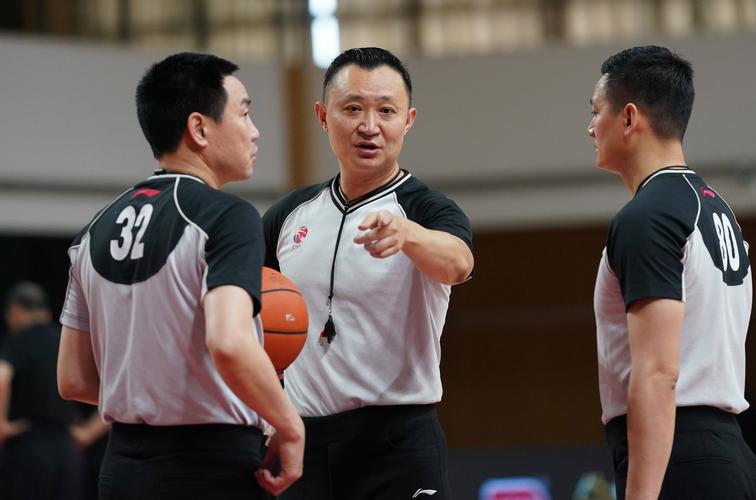 4月1日,主裁判闫军(中)在比赛间隙与第一副裁判杜溪源(左),第二副裁判