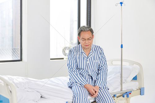 坐在病床边上沮丧的老人