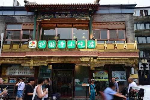 在北京街头随处走走,总能看见一家绿色牌头的店,名为"护国寺小吃".