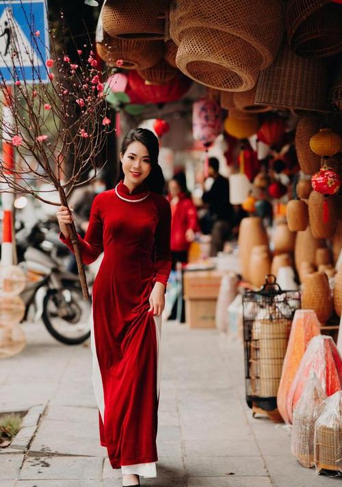 身穿红色奥黛,手持桃枝的越南姑娘,举手投足之间,甜美又温柔