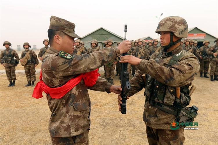 刘超把曾经用过的枪交接给班里的战士赵世鸣.