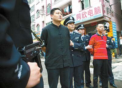 荷枪警察将犯罪嫌疑人带走.陈安,何波摄