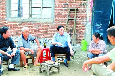 河南淅川县委书记袁耀生(左三)在移民群众家里了解搬迁准备情况.