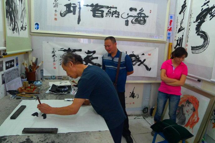 书画家胡俊峰在北京前门大手笔画室为董新有书写对联龙腾海浪高,马啸