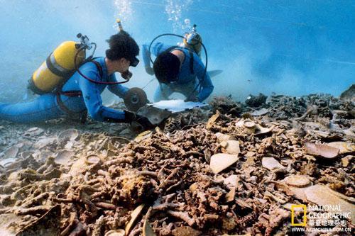 两位潜水员在海南西沙海域的华光礁i号遗址进行水下测量工作,以便提供