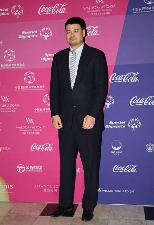 姚明身穿一身黑色西服套装,帅气挺拔,拍照时候脸上的表情非常有意思