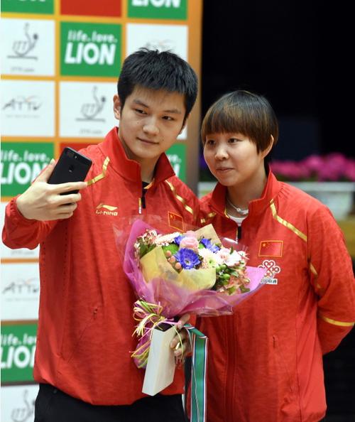 获得男单冠军的樊振东(左)与获得女单冠军的朱雨玲在颁奖仪式后自拍