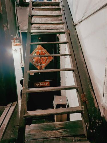 在墙壁上,需要上晒台的时候再翻下来,梯子正对着的木门,便是亭子间了