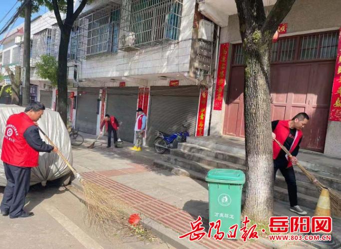 县区 华容县大扫除现场,志愿者们身穿红马褂,拿着大扫帚,垃圾袋等清扫