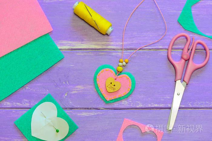 感觉心坠项链. 剪刀线毡纸模板在木桌上. 情人节珠宝工艺品.