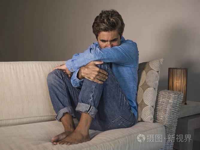 生活方式肖像年轻,有魅力,英俊,悲伤的拉丁男人,疲惫和沮丧地坐在家里