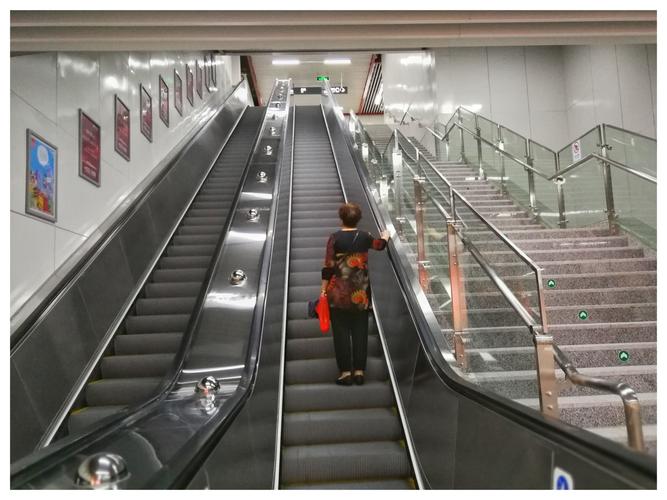 这是c口的自动斜面电梯,而在二电梯之间有人行步梯.