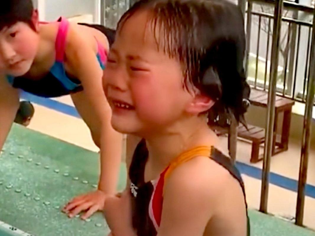 游泳馆里,一个五,六岁的小女孩在练跳水,她一路哭泣着从跳台下爬到