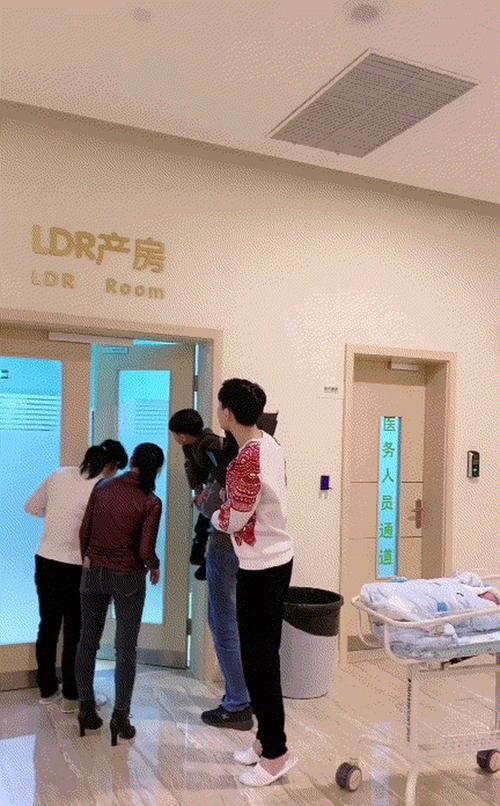 这时宝宝先推出产房,大家围了上去,爸爸并没有特别在意宝宝,而是踮着