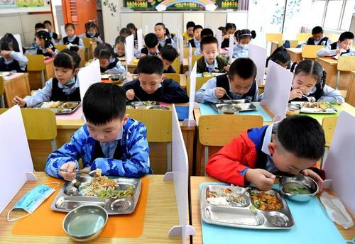 5月11日,陕西省西安市新城区后宰门小学一年级的学生在吃午饭.