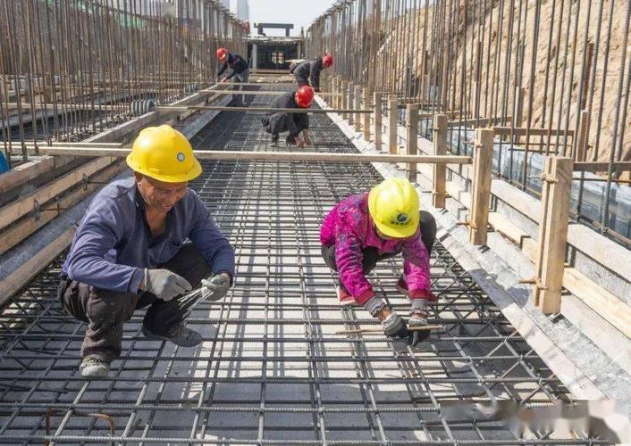 在大禹街施工现场,工人师傅在绑扎排水箱涵钢筋网.