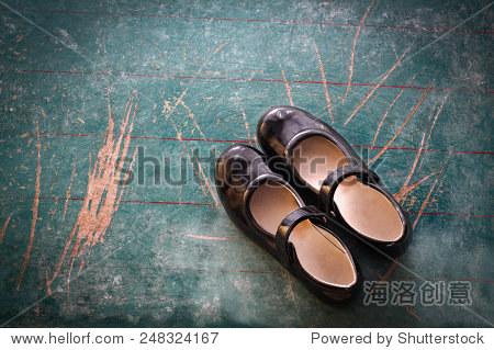 pair of girl shoes on old school board