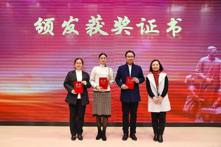宝山区教育学院干训部主任陈新(右一)颁发"四史教育"征文优胜奖证书