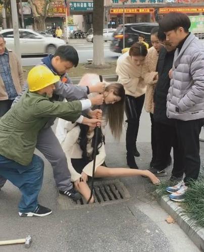 下半身穿着条黑色短裙和肉色丝袜,脚踩着一双高跟鞋的长发美女,一群人