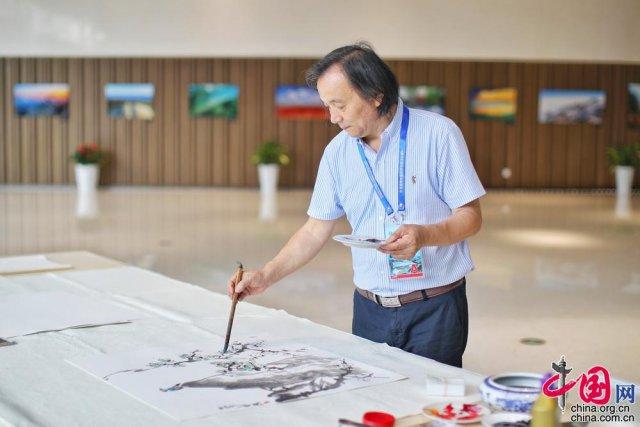 著名山水画家苏兆洪在新闻中心内进行绘画创作.中国网记者 郑亮摄