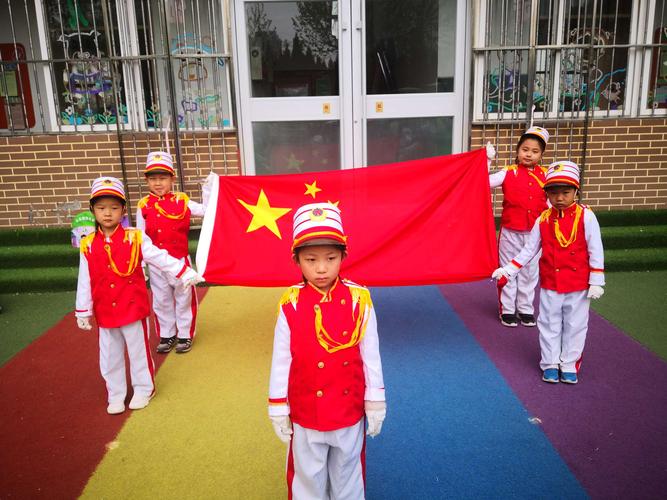 随着出旗曲音乐响起,我们的护旗手把国旗护送到升旗台