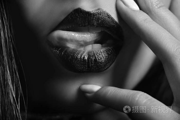 女性丰满圆润的嘴唇和皮肤光滑的黑色和白色照片
