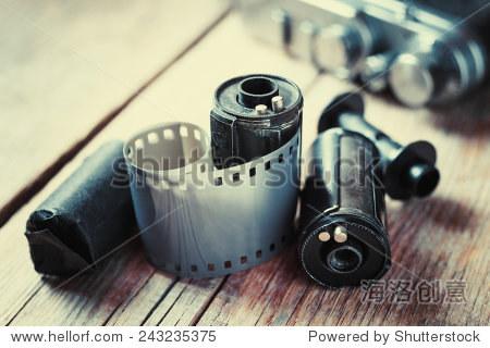 old photo film rolls, cassette and retro camera on background.