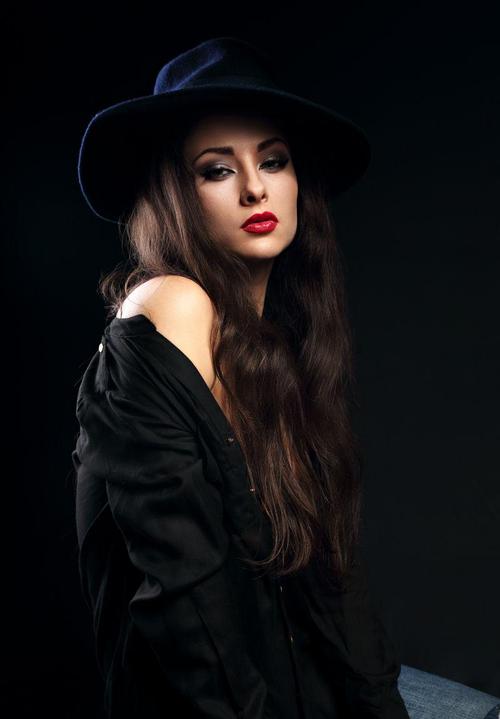 黑色背景下戴礼帽的妖娆美女