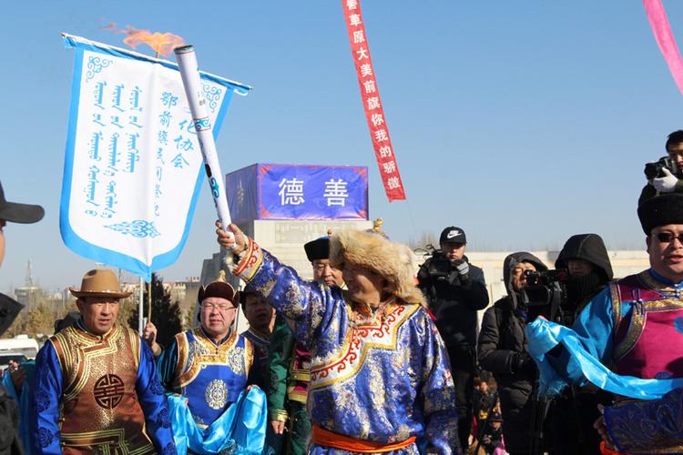纳贡毕力格手持在圣火火种上点燃的火炬向观众展示.