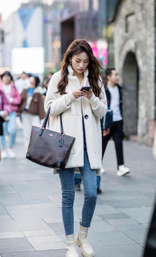 时尚街区的美女用白色短靴搭配秋冬装展现气质美