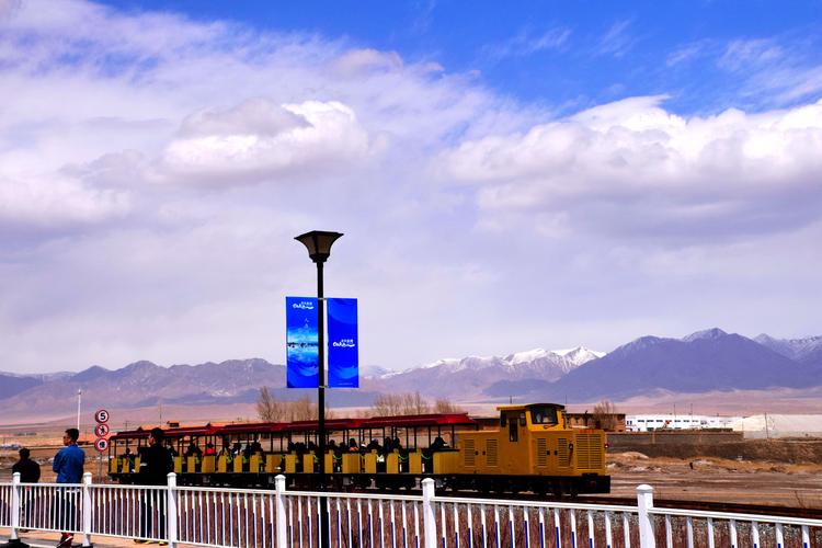 小火车行驶在堤上,与湖,雪山很搭配