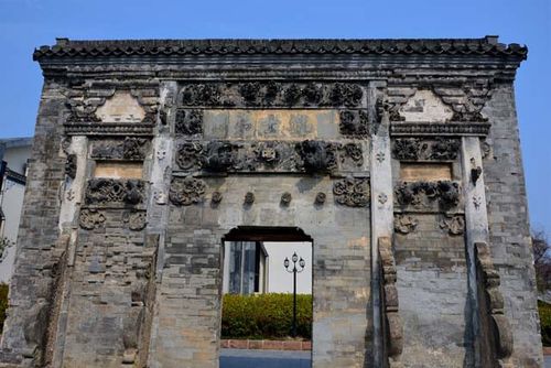 过桥就建有一座规模宏大的砖牌坊,说是牌坊,又有一个类似民居的门,搞