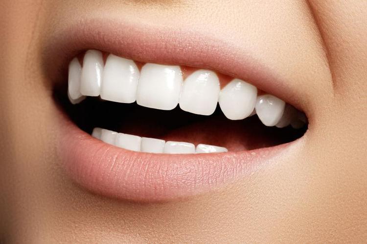 白色背景下用口镜的美女照牙齿