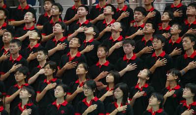 昨天,身穿崭新院服的2005级新生在升旗仪式上向国旗行注目礼.