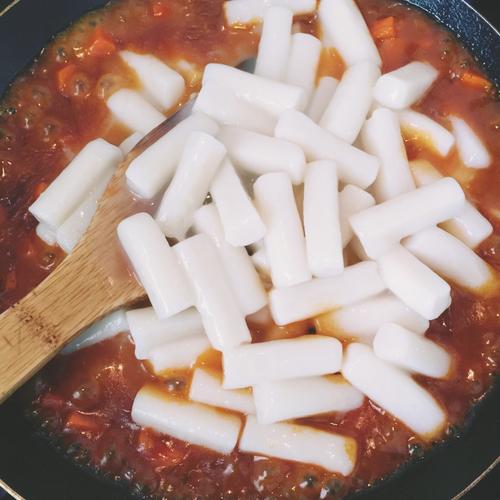 倒入事先煮好的年糕条,与锅中材料翻炒均匀.