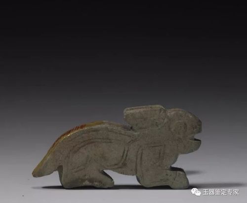 【青玉兔】 青玉兔,商,高1.25cm,长2.1cm,厚0.2cm.