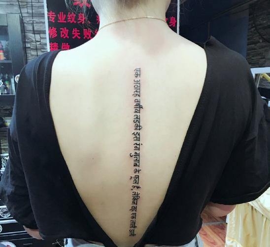 点击大图看下一张:脊椎部层次感十足的梵文纹身刺青