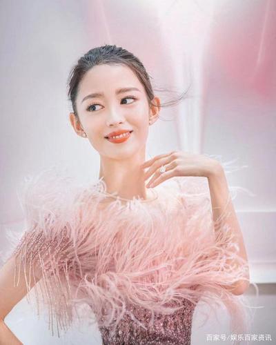 照片中吉娜身穿粉色亮片羽毛长裙.