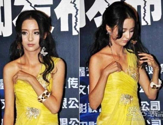 身穿黄色抹胸礼服的她因身穿太瘦小,礼服一直往下滑,为防止走光