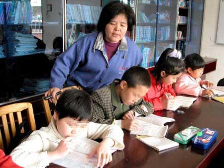3月14日,善恩园的丛建华老师在辅导孩子们做课外作业.
