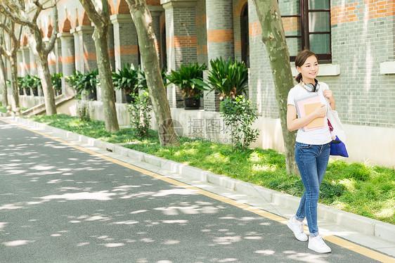 青春大学生抱着书本走路