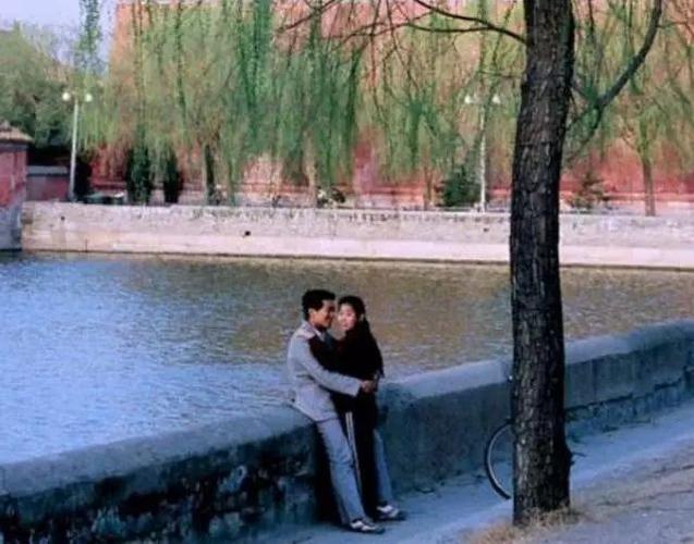 (公园约会的小情侣,女孩子看着镜头有点惊讶和尴尬)